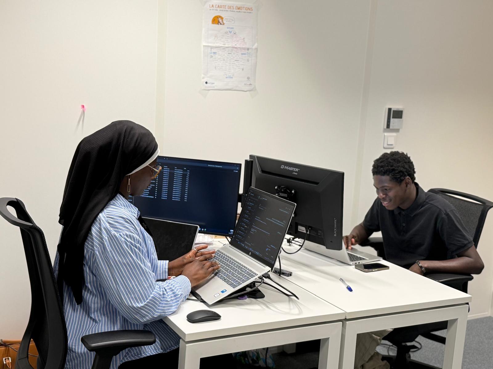 Un membre de l'équipe Student Global Link au bureau, devant deux écrans